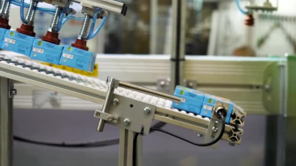 工厂输送带上的果汁盒由自动机器布置。媒体。机器人从生产线上取下彩色小纸箱. — 图库视频影像