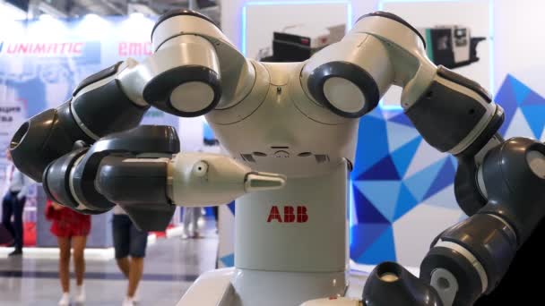 Industrial robotic machine at the industrial international exhibition, science concept. Media. Close up for a robot moving his arms with people moving on the background. — Stock Video