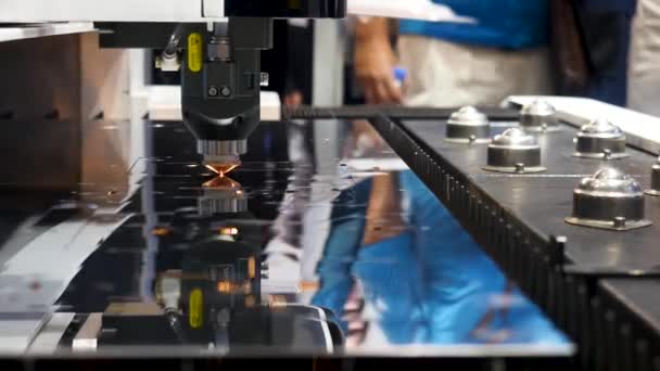 Промышленная лазерная машина резки металла, образец роботизированного механизма на международной выставке, технологическая концепция. СМИ. Плоский лист металлической стали, нарезанный блестками . — стоковое видео