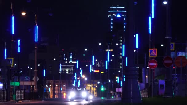 Vista de la ciudad nocturna con luces. Imágenes de archivo. Los senderos de luz en el fondo del edificio moderno — Vídeo de stock