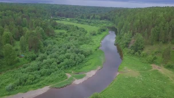 Vista aérea del hermoso río ruso situado entre prado verde y bosque mixto contra el cielo nublado en el día de verano. Imágenes de archivo. Pintoresca vista desde arriba de la naturaleza rusa — Vídeo de stock