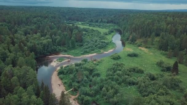 Vue aérienne de la belle rivière russe située entre prairie verte et forêt mixte contre ciel nuageux en journée d'été. Images d'archives. Vue pittoresque d'en haut de la nature russe 