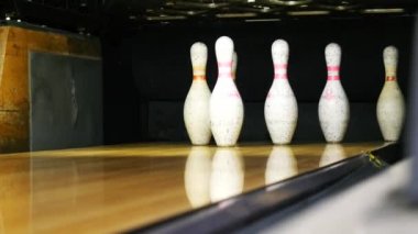 Bowling salonu nun sonunda duran bowling pimlerinin ve bir spor kulübünde ahşap yüzeyde yuvarlanan bowling topunun manzarası. Bir bowling komik spor hafta sonları