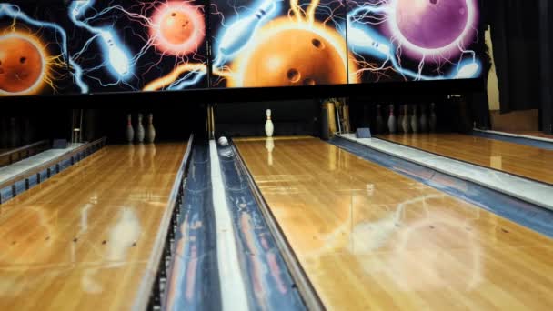 Les gens qui jouent au bowling - balle colorée frappant les quilles sur la piste de bowling dans un club de sport. Les médias. Le concept de système de retour de boules de bowling — Video