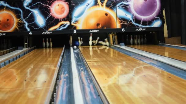 Mensen spelen Bowling-kleurrijke bal het slaan van de bowling pinnen op bowlingbaan in een Sport Club. Media. De bowling ballen retour machine systeemconcept — Stockvideo
