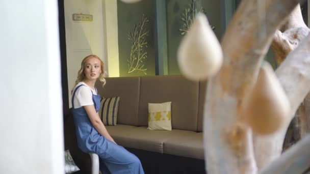 Jeune blonde posant à la caméra à la maison. L'art. Belle jeune femme blonde en chemise blanche à la caméra dans la chambre — Video