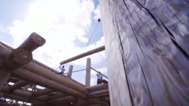 Vinç kancası odun tutuyor. Klip. Vinç bir şantiyede kirişi kaldırır. Şantiyede çalışma
