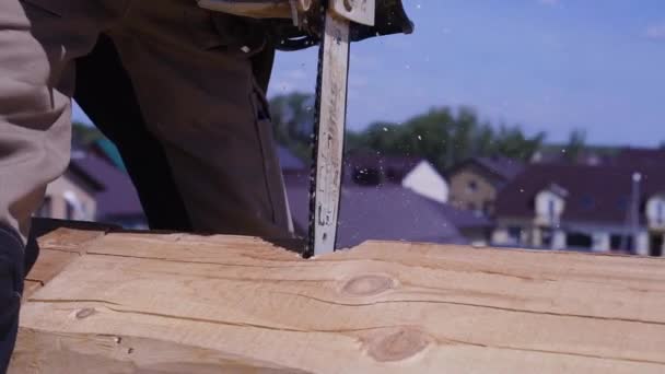 Trabajador aserrando una motosierra de madera. Clip. Primer plano de la sierra de serrado de madera en movimiento, el aserrín vuela a los lados — Vídeos de Stock
