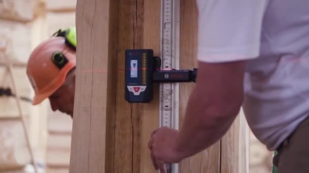 Working measures the height of the laser device. Clip. A young construction engineer makes room measurements with a laser roulette — Stock Video