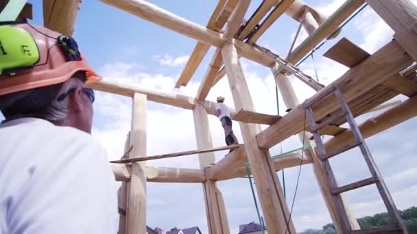 Sitio de construcción de monitoreo de ingenieros. Clip. Inspección de edificios por ingeniero. Foreman en un casco supervisa la construcción de la casa — Vídeo de stock