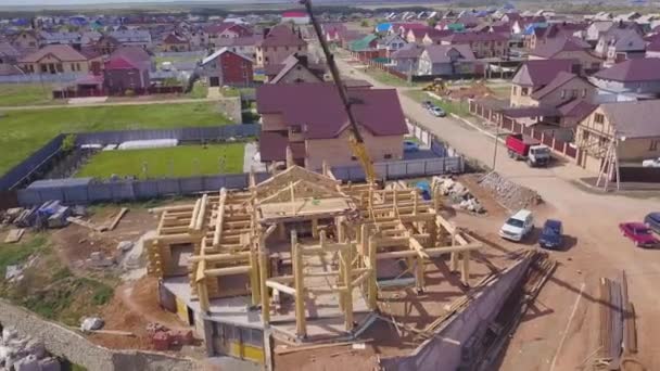 木造住宅を建てるプロセスのトップビュー。クリップ。サポートパイプに木製の天井梁を備えた小さな未完成の建物 — ストック動画
