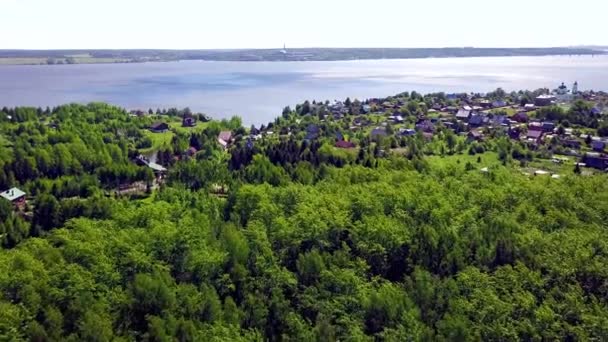 Cottage Town på bakgrund Blue Lake. Klipp. Top utsikt över en landsby i ett skogsområde vid sjön — Stockvideo