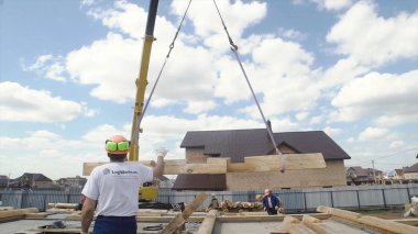 Şantiye vinç bina ev için kaldırıyor. Klip. Vinç bir ev inşa etmek için