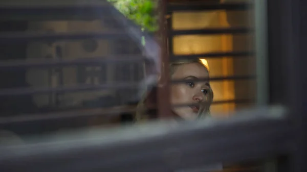 La joven mira por la ventana de la casa. Art. Hermosa rubia mirando por la ventana —  Fotos de Stock