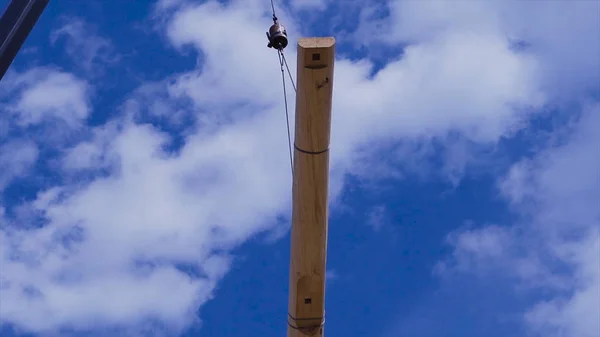 Crane soulève la bûche. Clip. Grue soulève du bois pour la construction d'une maison en bois — Photo