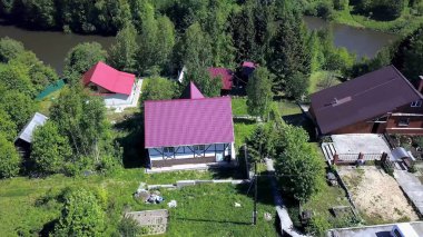 Güzel hava ile yaz aylarında orman manzaralı hava köyü. Klip. Yaz aylarında ormanda köyün üst görünümü