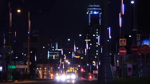 Vista na cidade noturna com luzes. Imagens de stock. As trilhas de luz no fundo do edifício moderno — Fotografia de Stock
