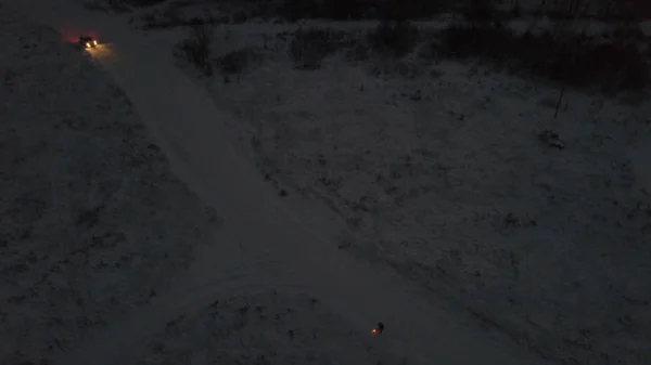 冬の夜、街の外の白い車の近くの雪に覆われた道路上で花火を撮影人の空中ビュー。ストック映像だお正月やクリスマスのお祝い — ストック写真