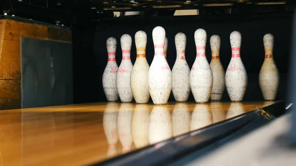 Detailní pohled na bílé špendlíky stojící na konci bowlingového pruhu a valící se bowlingová koule ve sportovním klubu. Média. Vtipné sportovní víkendy v bowlingu — Stock fotografie