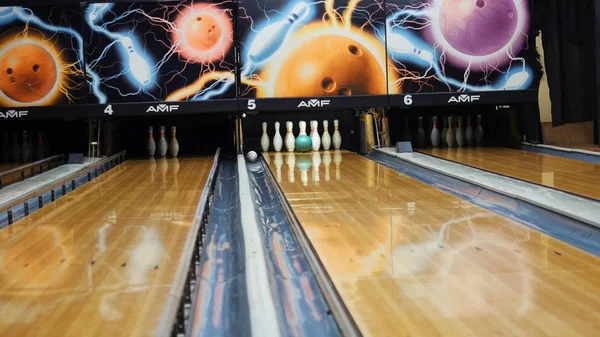 Vista della palla colorata che colpisce i birilli da bowling sulla pista da bowling in un club sportivo. Media.The bowling palle ritorno macchina concetto di sistema — Foto Stock