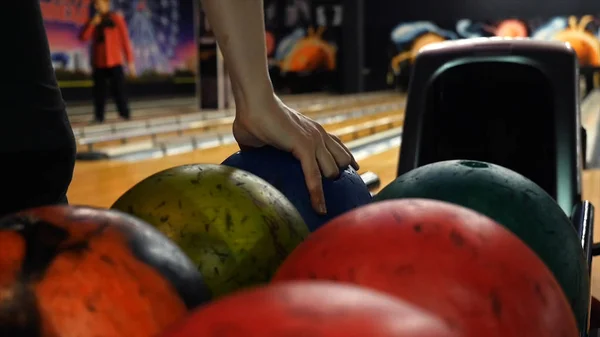 Vista ravvicinata della mano del giocatore di bowling che prende la palla colorata dall'ascensore della ciotola. I media. Persone che giocano a bowling - il concetto di sistema di ritorno palle da bowling — Foto Stock