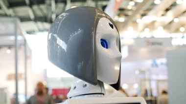 Hareket eden ve mavi gözlü dişi robotun kafasını konuşan yakın plan. Medya. Robotik forum sergisinde sunulan farklı çalışan robot koleksiyonu