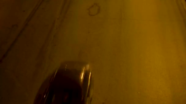 Autos, die nachts auf asphaltierter Straße fahren. Archivmaterial. Blick von oben auf vorbeifahrende Autos auf der Autobahn mit leuchtenden Scheinwerfern in der Nacht — Stockvideo