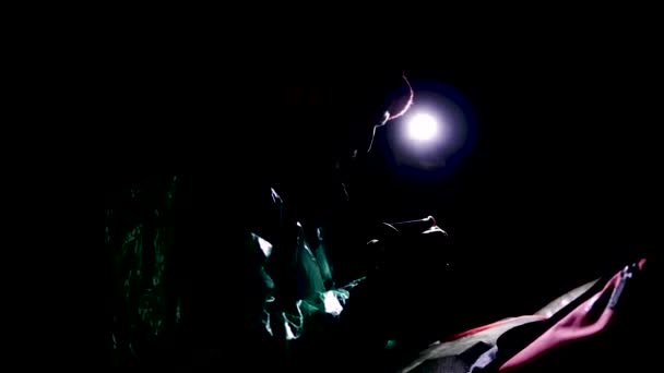Člověk v noci v přírodě sedí s baterkou. Skladní záběry. V naprosté tmě hustého lesa sedí pod stromovým mužem a osvětlovat jeho místo světlem lucerny — Stock video