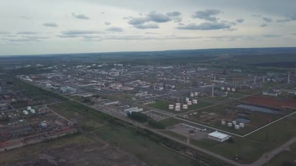 Vista dall'alto della grande area industriale situata fuori città con campi e alberi sullo sfondo a cielo nuvoloso. Clip. Incredibile vista delle fabbriche serbatoi e serbatoio fattoria . — Video Stock
