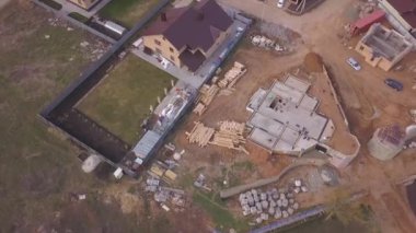 Yeni modern yazlık, inşaat malzemeleri ve inşaat malzemeleri vakıf için beton dökme yakın devam eden şantiye havadan görünümü. Klip. Yeni bina yapım süreci.