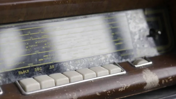 Close up de um antigo receptor de rádio com fricção e botões brancos, estilo retro. Acção. Diferentes estações e frequências do rádio vintage e a reflexão do homem no painel de vidro . — Fotografia de Stock