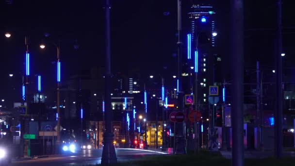 Luces modernas de la ciudad por la noche en la carretera ocupada. Imágenes de archivo. Autopista de la ciudad está iluminada con luces de neón y faros de coches que pasan — Vídeo de stock
