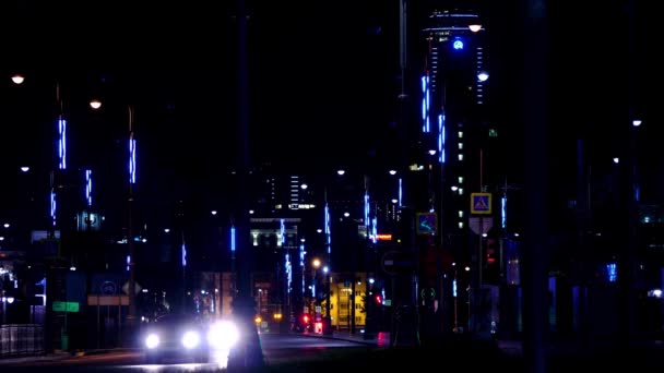 Luces modernas de la ciudad por la noche en la carretera ocupada. Imágenes de archivo. Autopista de la ciudad está iluminada con luces de neón y faros de coches que pasan — Vídeo de stock