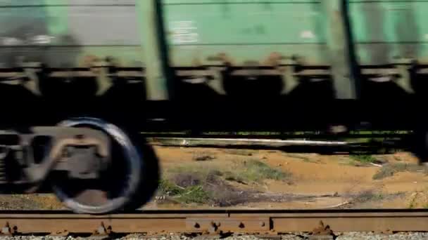 Gite in treno sul paesaggio montano in estate. Filmati delle scorte. Vista di ruote di passaggio treno sullo sfondo del deserto terreno montagnoso. Concetto di viaggio. Treno merci — Video Stock