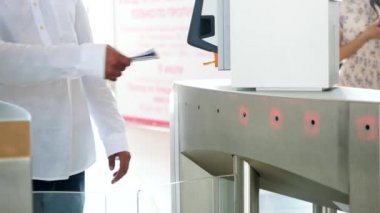 Beyaz gömlekli ve mavi kot pantolonlu adam barkod tarayıcı ile elektronik turnike geçiyor. Medya. İş merkezi için erişim kontrolü, yakın çekim