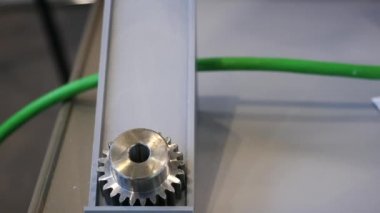 Otomatik robot cihazın yanında masanın üzerinde yatan küçük metal dişlilerin yakın çekim. Medya. Elektronik cihazlar ve mekanizmalar bilimsel sergide sunuluyor.