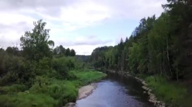 Ormandan geçen nehrin panoramasının en iyi görünümü. Stok görüntüleri. Gökyüzünü ve çevredeki ormanı yansıtan nehrin güzel manzarası