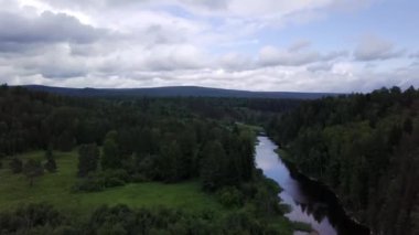 Ormandan geçen nehrin panoramasının en iyi görünümü. Stok görüntüleri. Gökyüzünü ve çevredeki ormanı yansıtan nehrin güzel manzarası