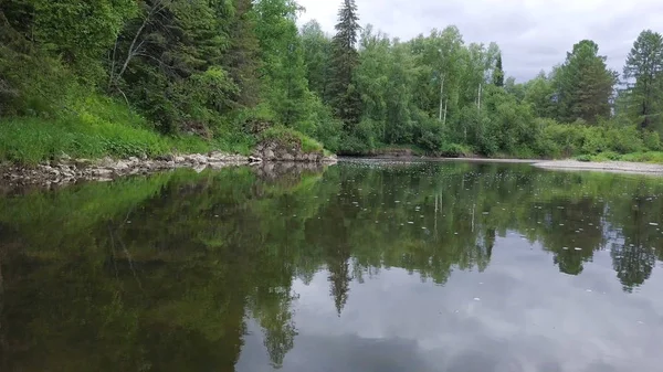 Vue de dessus du reflet clair du ciel et de la forêt dans le lac. Images d'archives. Eaux calmes reflétant un paysage semblable à un miroir forêt verte — Photo