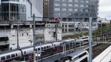 Demiryolu yakınında modern geometrik evler. Eylem. Banliyö bölgesinde demiryolu yakınında yapım aşamasında modern tasarım evler. Bulutlu havalarda inşaat sırasında Modern sıradışı evler