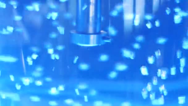 Close-up van kokend water en metalen buis in een grote plastic koeler met een neon achtergrondverlichting. Media. Zuiverste water in koeler met bubbels wordt verlicht met kleurrijk licht — Stockvideo