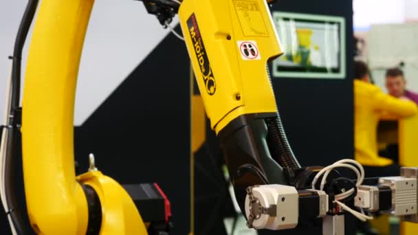 Крупный план большого желтого робота машина ручной установки некоторых электрических устройств. СМИ. Различные коллекции роботов представлены на выставке форума робототехники — стоковое видео