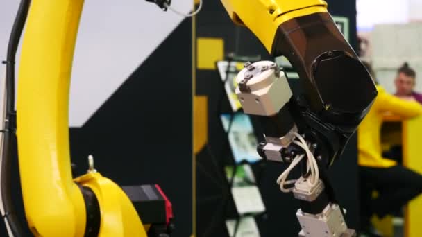 Primer plano de la gran máquina robot amarillo mano la instalación de algún dispositivo eléctrico. Medios. Diferentes colecciones de robots de trabajo presentadas en la exposición foro de robótica — Vídeo de stock