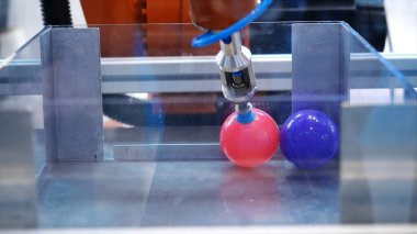 Robotik makine el küçük plastik çok renkli topları taşınması yakın çekim. Medya. Robotik Forumu sergisinde farklı çalışan robotlar koleksiyonu sunuldu