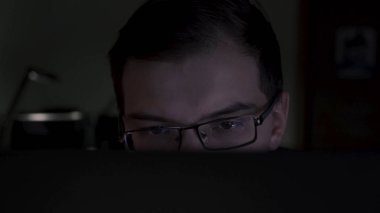 Yakından monitöre bakan genç programcının yakın çekim. Stok görüntüleri. Genç çekici ofis çalışanı bilgisayar bitirme raporları gece geç saatlerde çalışıyor