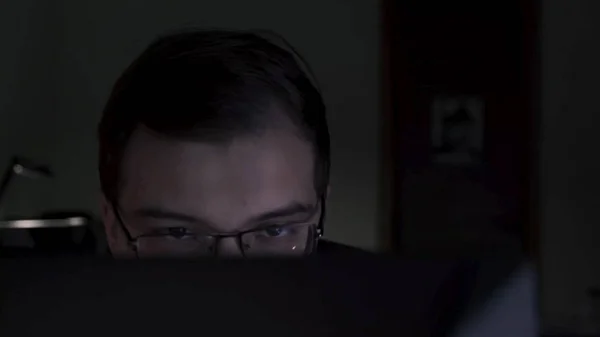 Close-up do jovem programador olhando atentamente para o monitor. Imagens de stock. Jovem trabalhador de escritório atraente trabalhando até tarde da noite em relatórios de acabamento de computador — Fotografia de Stock