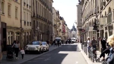 Paris, Fransa - Haziran, 2019: Eski mimari ve yürüyen insanlarla dar Avrupa caddesi. Eylem. Güzel Avrupa sokak saraya bakan. Turistler güneşli Avrupa şehrinin sokak boyunca yürümek