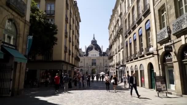 Parijs, Frankrijk-juni 2019: smalle Europese straat met oude architectuur en wandel mensen. Actie. Prachtige Europese straat met uitzicht op paleis. Toeristen lopen langs de straat van de Europese stad in Sunny — Stockvideo