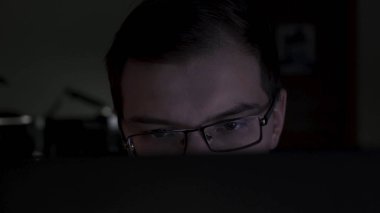 Yakından monitöre bakan genç programcının yakın çekim. Stok görüntüleri. Genç çekici ofis çalışanı bilgisayar bitirme raporları gece geç saatlerde çalışıyor