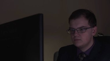 Ofis çalışanı gece geç saatlerde bilgisayar başında oturuyor. Stok görüntüleri. Ofis çalışanı raporları bitirmek için ofiste geç mesai yapmak zorundadır